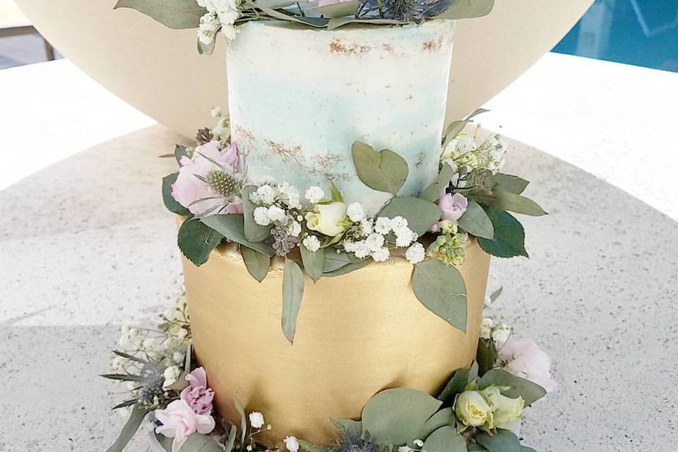 Blue watercolor and metallic gold buttercream wrapped in wild flowers