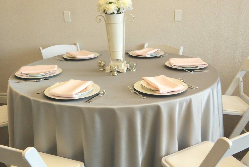 Silver dupioni table cover, white charger plate, white and silver china, lilac napkin. White resin folding chairs.Rental items from Lake Party Rentals, Lake of the Ozarks, MO.