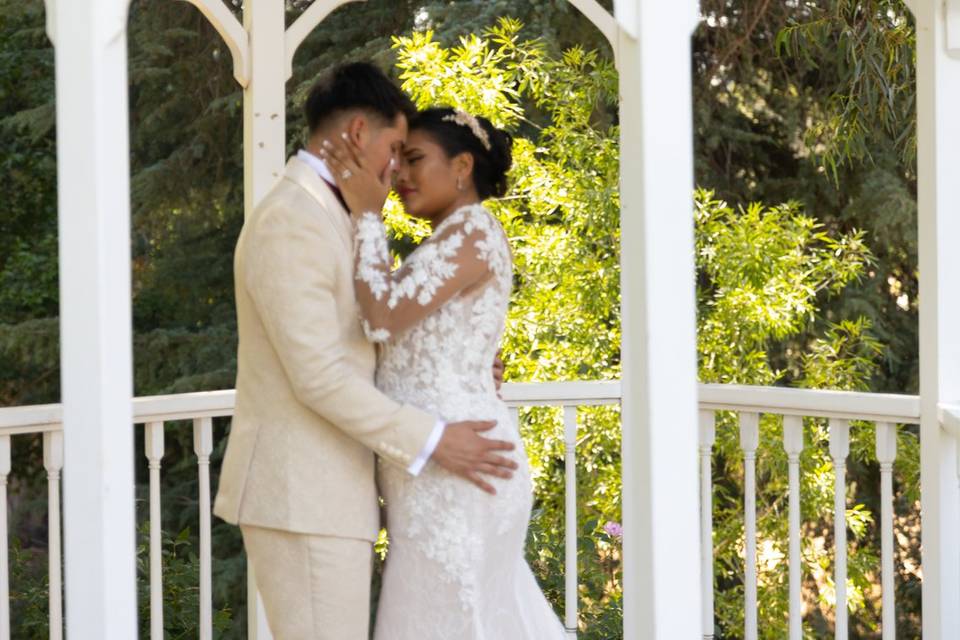 Newlyweds emrbrace under the gazebo