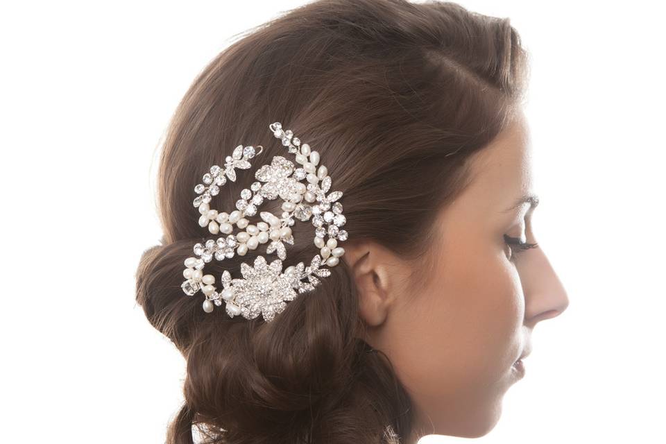 LORAY PEARL & CRYSTAL HAIR PIECE
Adorn your bridal hairdo with a versatile brass hair clip, embellished with clear crystals and freshwater pearls, lending glamour with a touch of ethereal elegance. Featuring a rhodium plated setting, this hair clip speaks opulence and high quality all while remaining versatile through its extendable wire brass.
http://www.delilahk.com/delilahkbridal/bridal-hair-pieces/loray-pearl-crystal-hair-piece.html