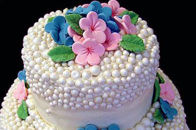 Neat 2 tier cake with superb dot work and varying handcrafted flowers!