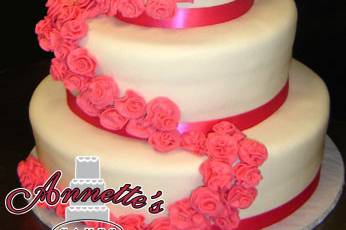 Sleek looking 4 tier cake with blush colored ribbon work and a beautiful miniature rose trail.