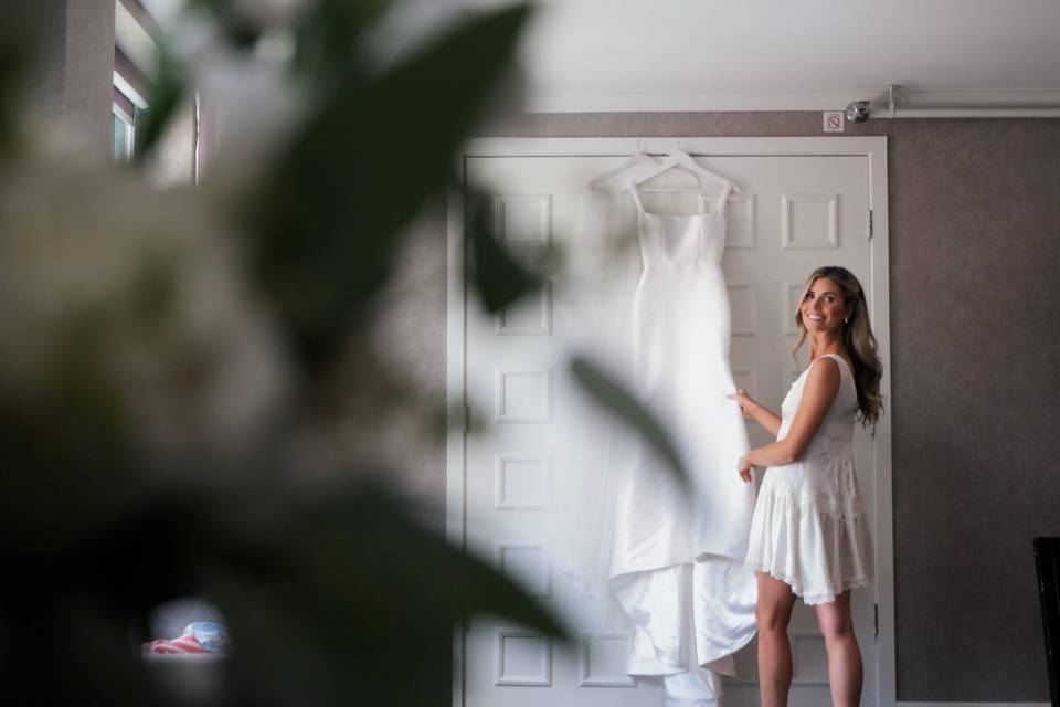 Happy bride peaks at dress