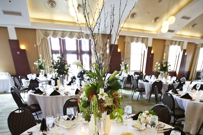 Wedding reception setup with tall floral centerpiece