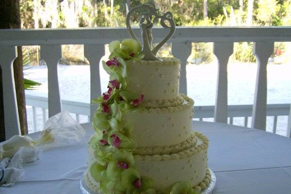 This elegant wedding cheesecake has a swiss dot design with breath taking lillies cascading down.