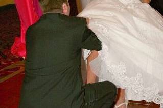 Groom's removing the wedding garter from his bride