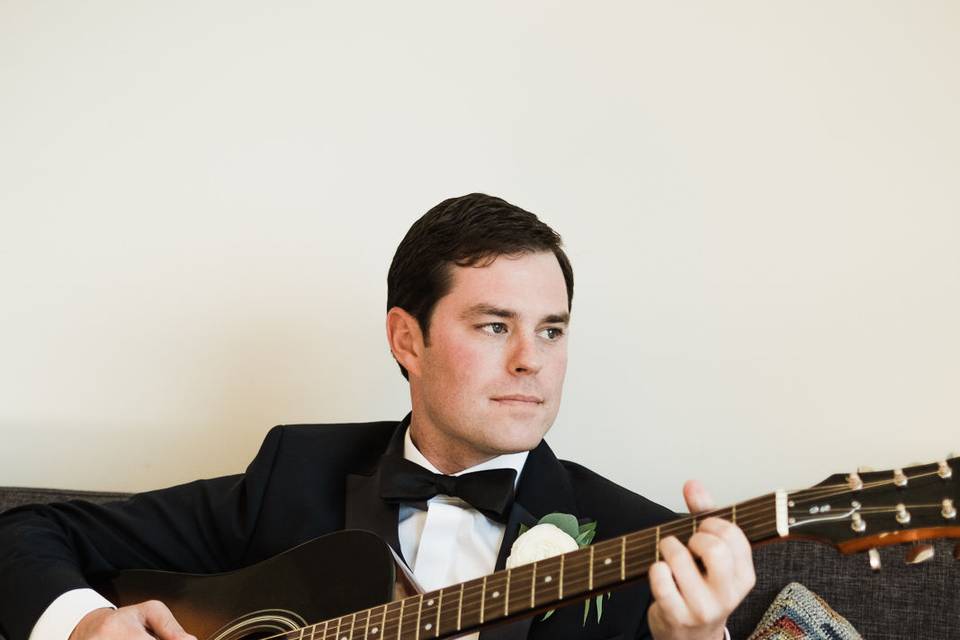 A groom plays guitar at his Downtown Seattle wedding.