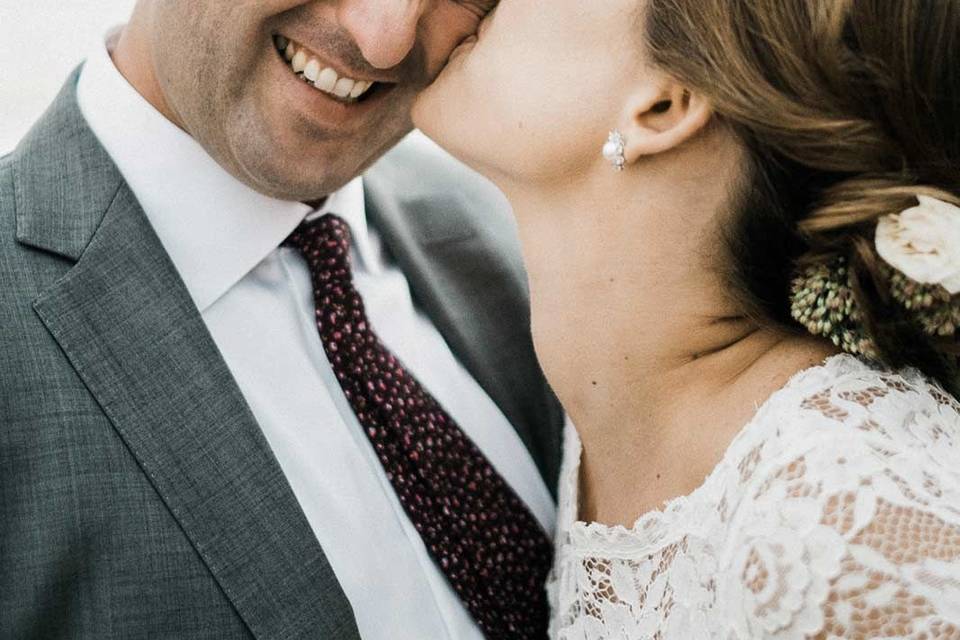 A bride kisses her new husband at their wedding at Kiana Lodge.