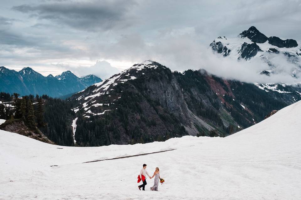 A couple walks through a snow field during an Adventure Engagement on Mt. Baker.