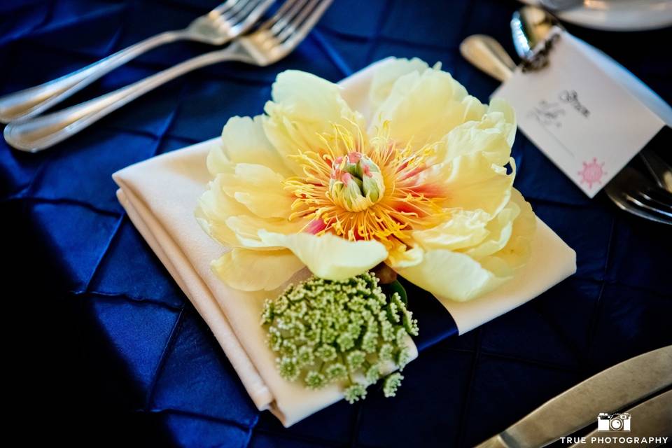 Large yellow peony and queen anne's lace used to decorate the sweetheart table place settings.