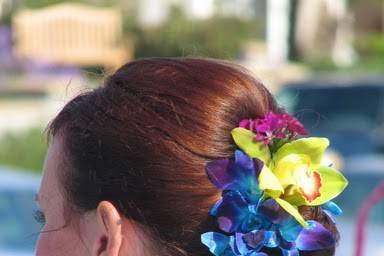 Bright dendrobium and cymbidium orchids as well as sweet william adorn this bride's hair.