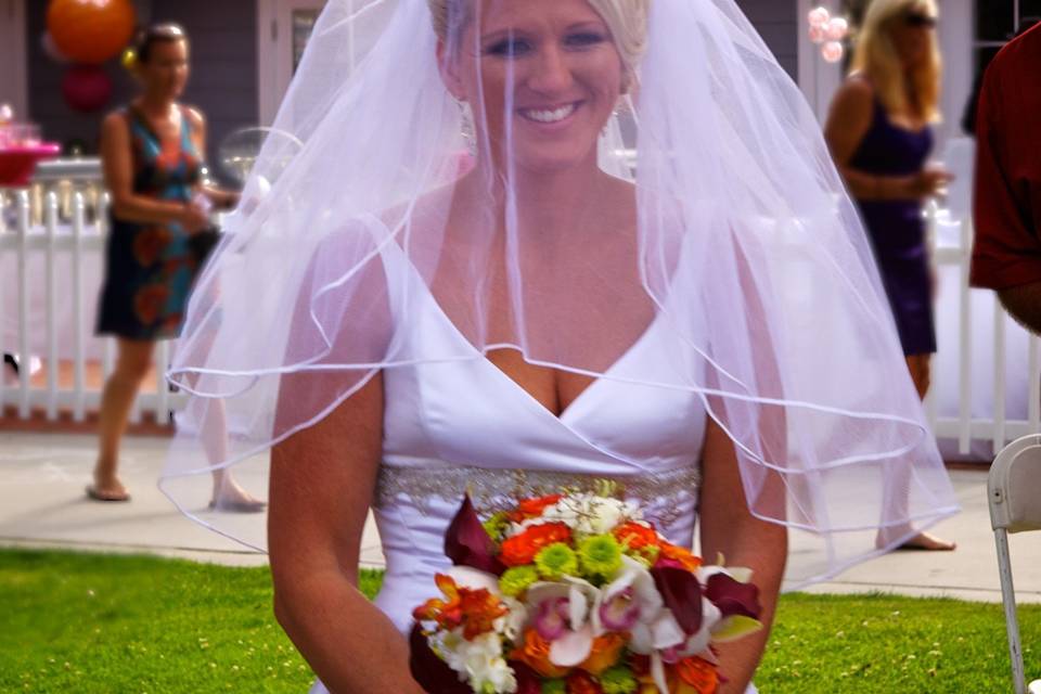 Vibrant citrus colors in the bouquet compliment the bride's white dress.