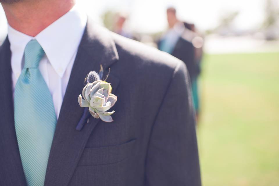 Clean boutonniere with a succulent and sea holly.