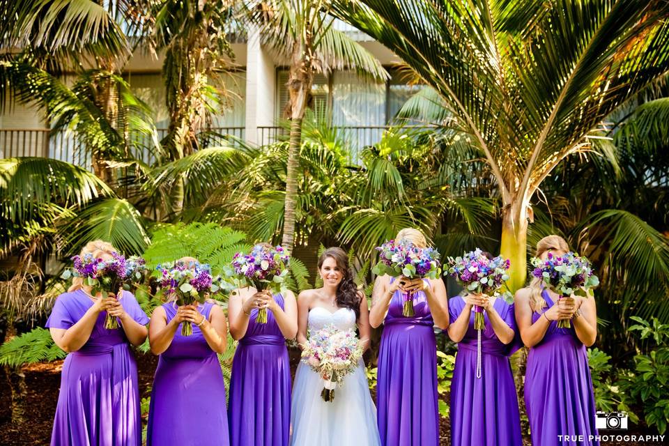 Bouquets in shades of purple for the bridesmaids and pastels for the bride with pearlized shells included in each one.