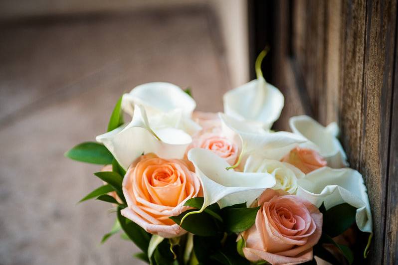 Classic and elegant bouquet with peach roses, white calla lilies and ruscus.