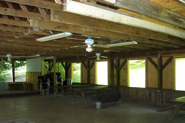 There is a small stage, ceiling fans, electric out-lets, and a large barrel wood stove.  Pic-nic tables can go inside or outside.  You can bring round tables w/colorful table clothes and flowers and decorate any way you want, but it will never be fancy...this is not the place for a picky wedding.