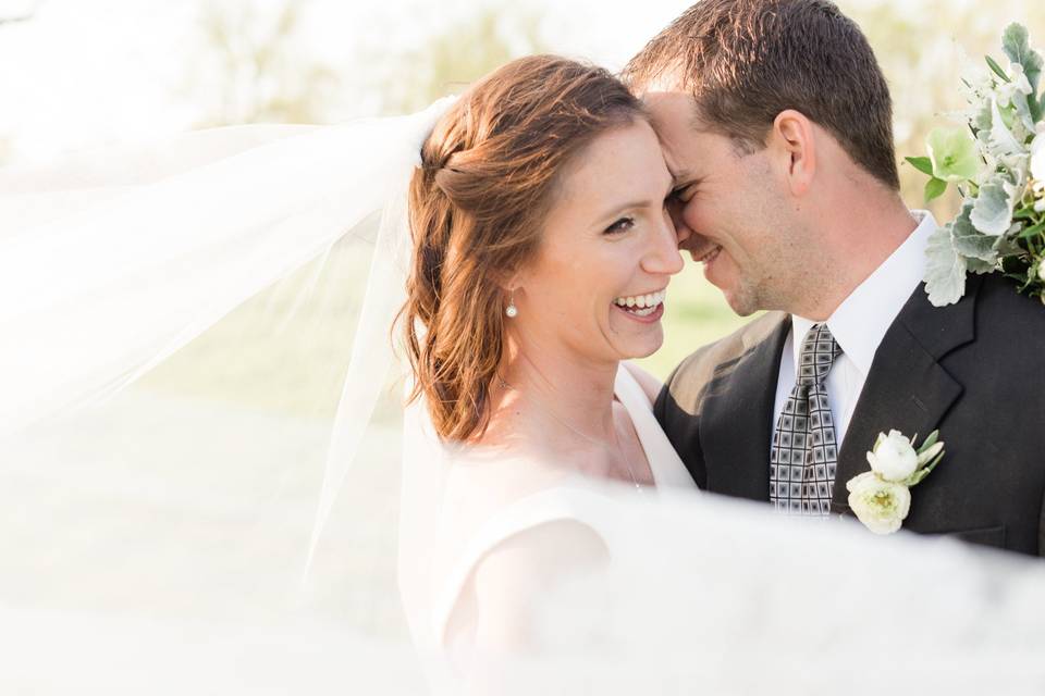 Bride and her groom with her veil flowing