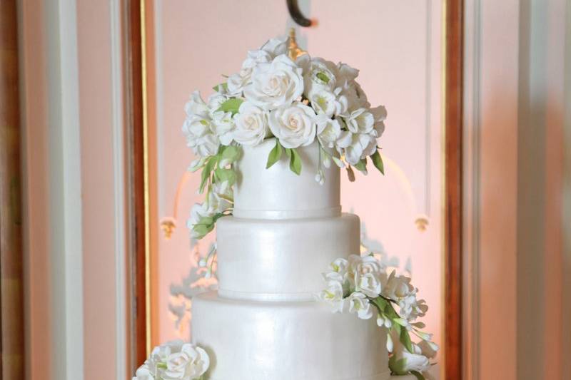 Ana Parzych Custom CakePearlized white fondant tiers with cascading white hand-crafted sugar roses and leaves.