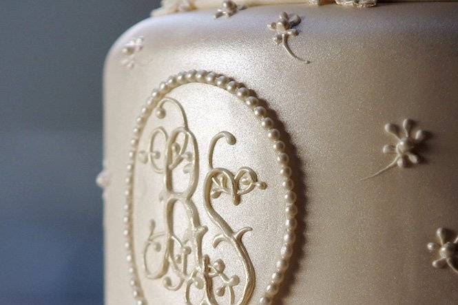 Ana Parzych Custom Cake Cake detail. Gum paste plaque detail with piped monogram and fondant molded pearls.