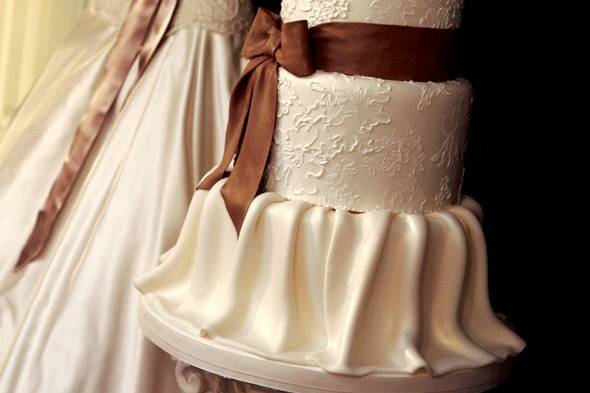 Ana Parzych Custom CakeWedding cake inspired by bride's gown.  Featuring piped lace, gum paste ribbon and bow and fondant molded skirt.