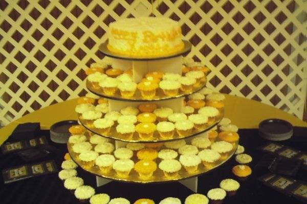 Standard size cupcakes placed on a round pyramid stand, with an 8in. round layered cake at the top.