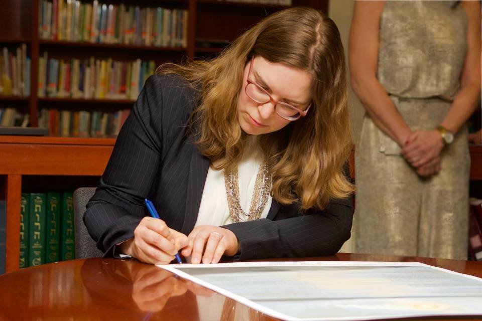 Rabbi signs the marriage document