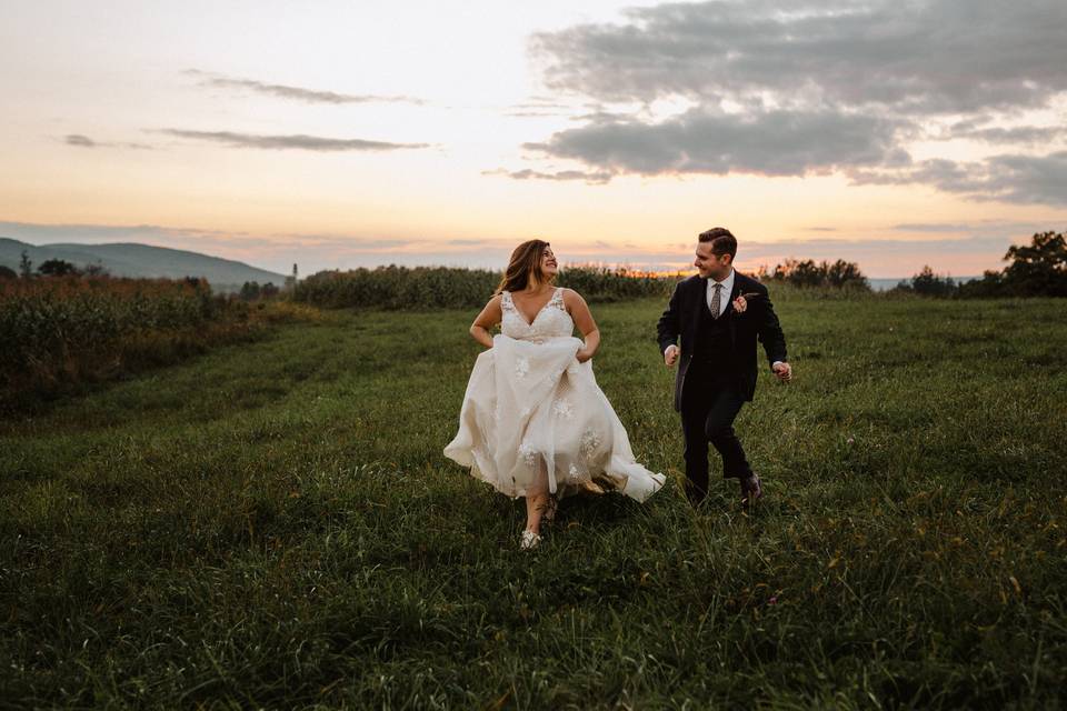 Newly weds walking through a field