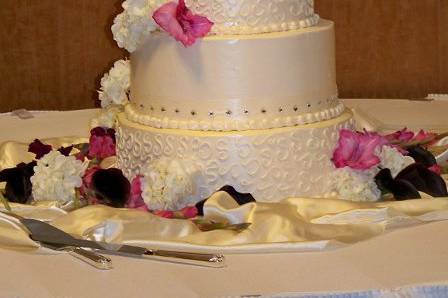 This cake was iced and decorated in buttercream icing.  Rhinestone studded ribbon adorn two of the tiers.