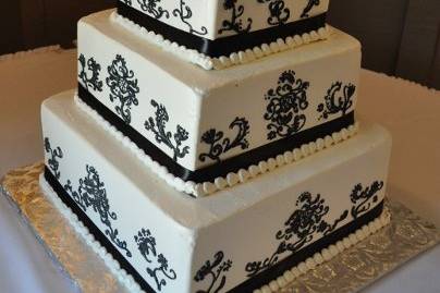 Buttercream icing and freehand damask style sidework design to match the wedding couple's invitation.