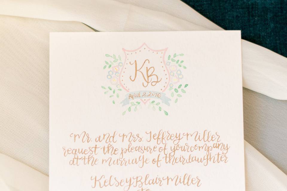 This invitation suite was designed around a custom watercolor monogram for the bride and groom. The custom watercolor monogram adorns the top of the invitation, with gold calligraphy completing the rest of the invitation suite.