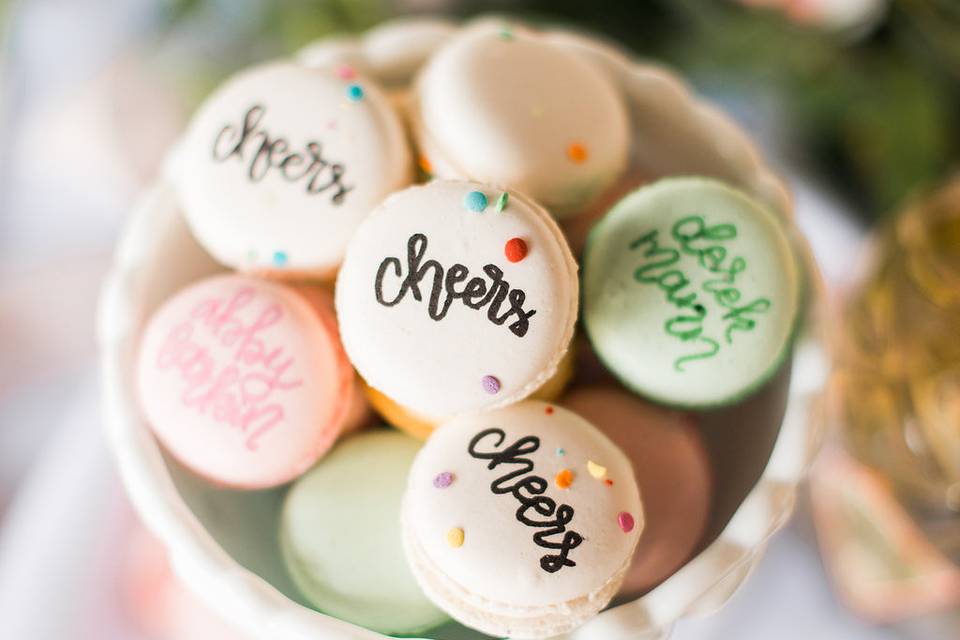 The bride and groom chose macarons as one of the desserts for their big day. The macarons were calligraphed with the names of each guest and fun messages.