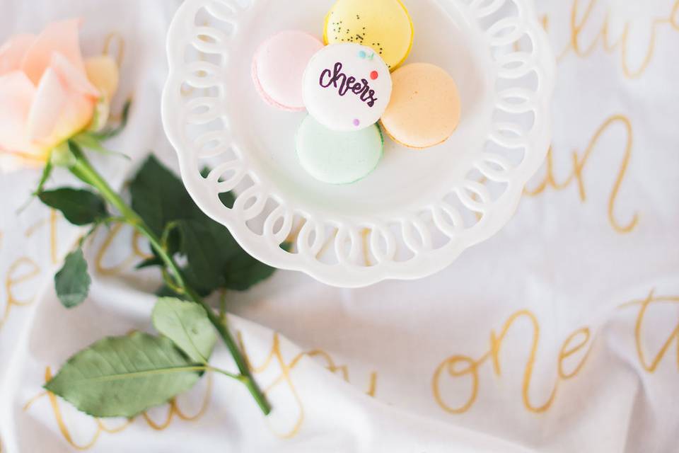 The bride and groom chose macarons as one of the desserts for their big day. The macarons were calligraphed with the names of each guest and fun messages.