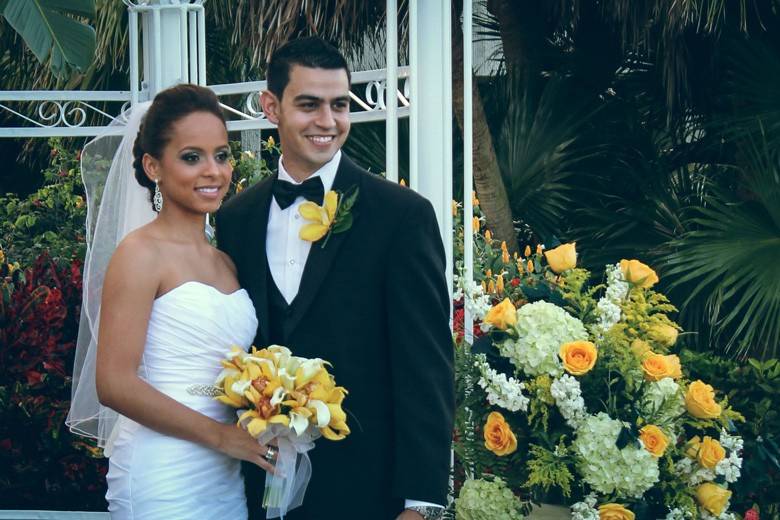 Bride and groom surrounded by yellow flowers