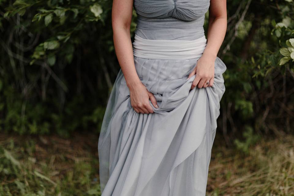 Denver industrial wedding bride holding her dress.