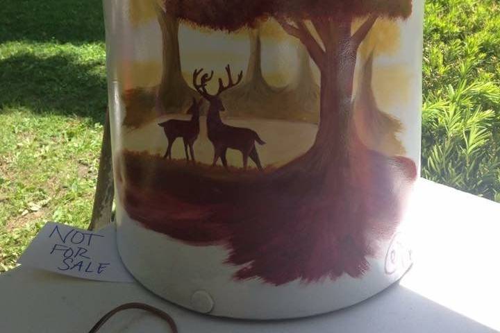 An old milk can, painted and set out as a welcome sign.