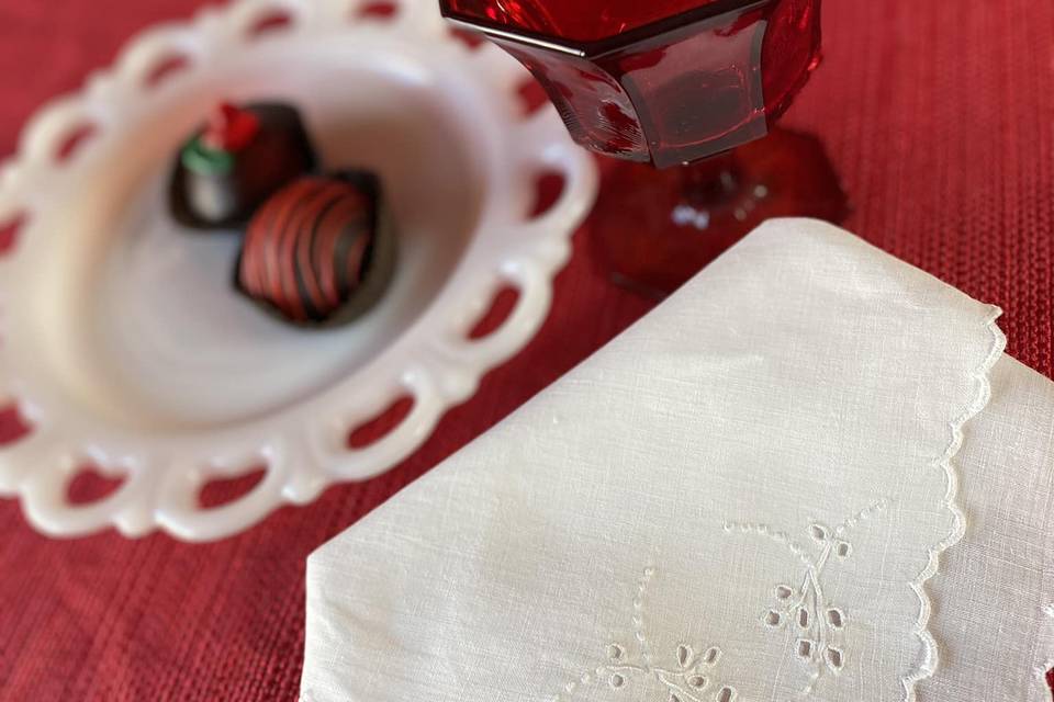 Red glass and embroidered napkins