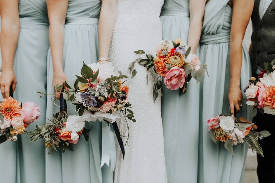 Bride and her bridesmaids holding a bouquet