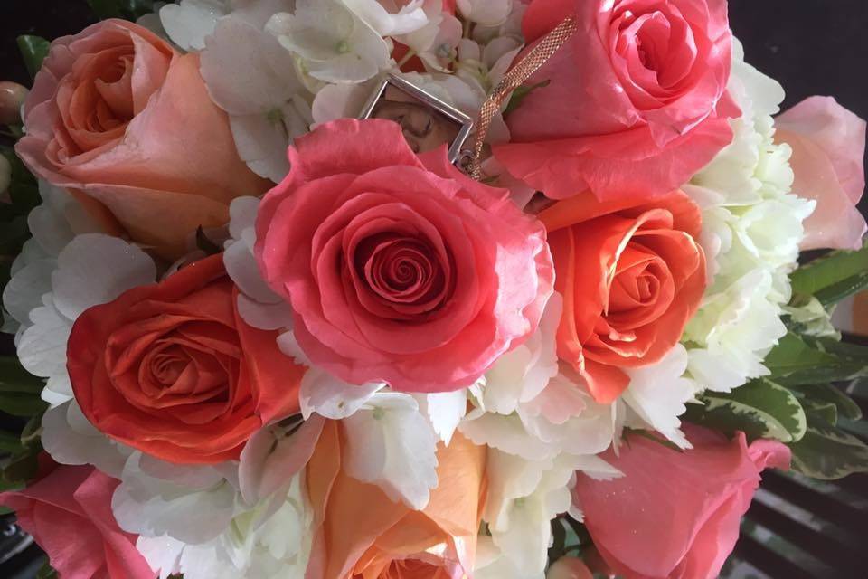 White hydrangea, Amsterdam Roses, coral reef roses, and orange crush roses. Peach hypericum berries