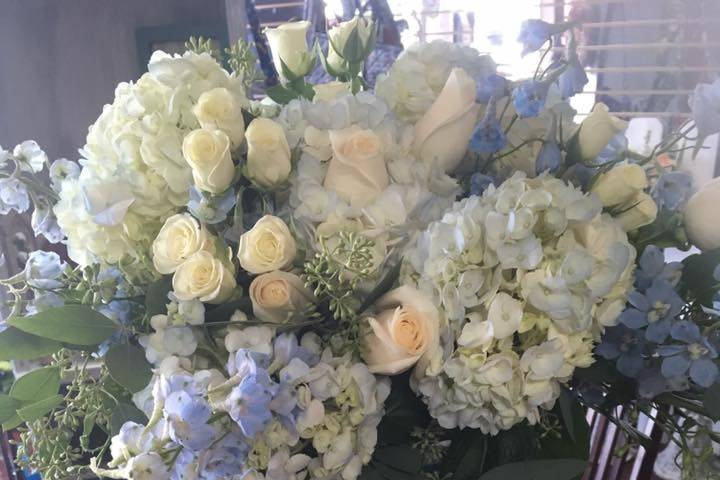 Ceremony arrangement white hydrangea, blue delphinium, vendella Roses, majolika spray roses