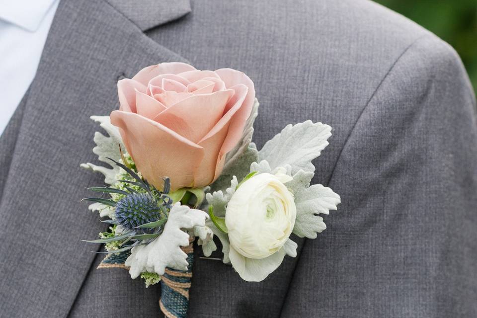 Amnesia rose, blue thistle, and white ranunculus boutonnière