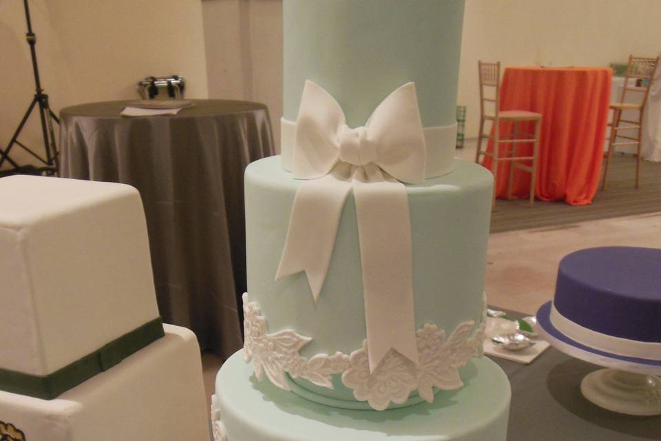 Fondant bow and floral patterns on a four tiered wedding cake