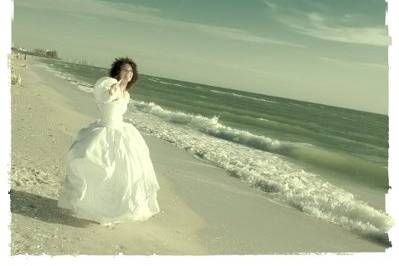 Bride flying kite down the beach