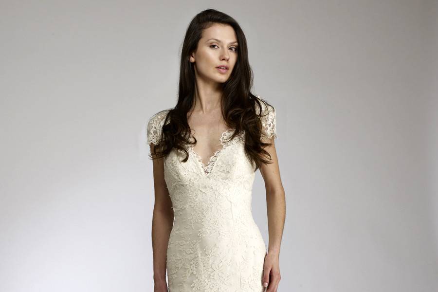 AstridV-Neck front & back slim fit to flair gown with cap sleeves.  Cut from imported delicate lace, meticulously placed.  A ruffle of lace cascades down her back splitting into two down to hem.