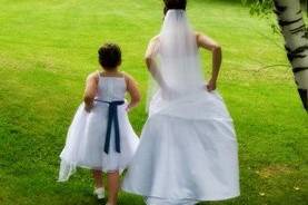 The bride and flower girl make their way across the lawn for formals.