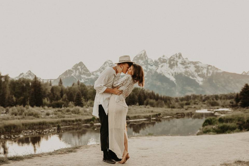 Couple kissing beside a mountain range