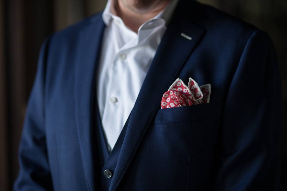 The groom wears a handkerchief pocket square (in case of tears).