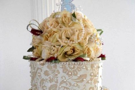 Cake topper of roses, lotsof pearl, and tri color ribbon loops for simple elegance.