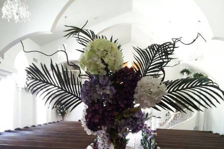 Large Arrangement for altar, hydrangeas, wysteria, and palm branches give and open feeling.