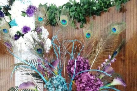 Regal is the word that comes to mind when joining these colors together.  Turqoise hydrangeas, eggplant callas and hydranges, wysteria, crowned with a spray of palm branches and peacock feathers.