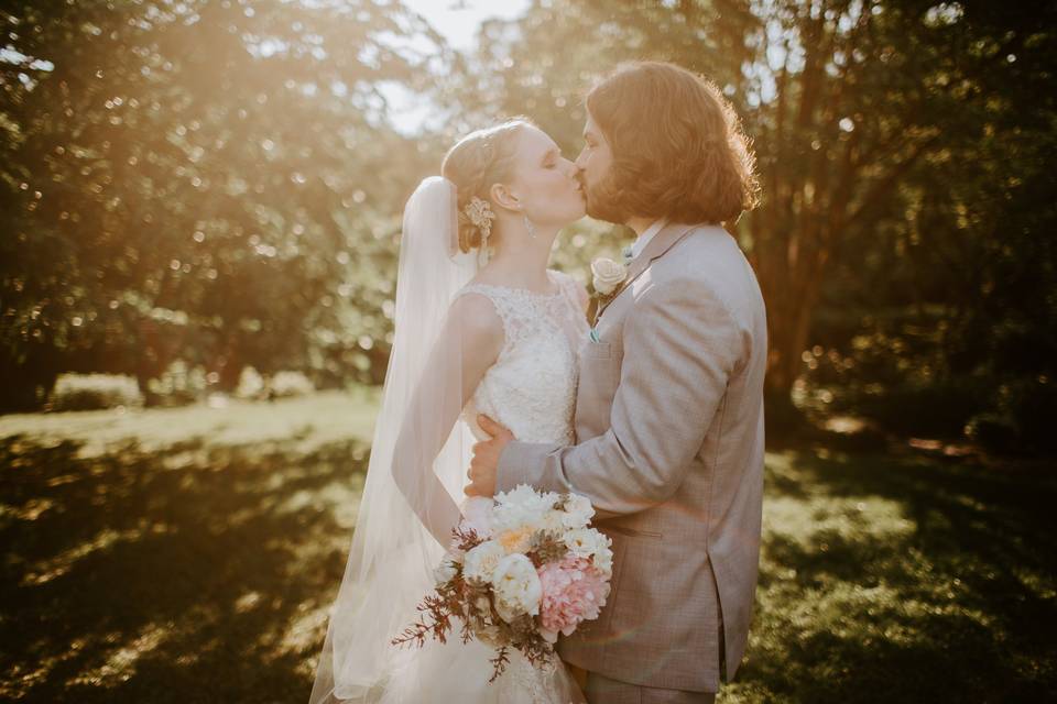 Bride and groom kissing sun